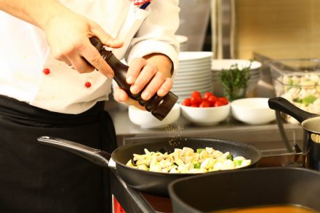 professional cook in kitchen preparing food for customers showing hands and utilities